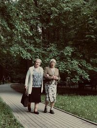 Full length of woman standing against trees