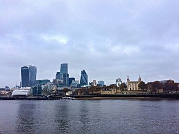 Buildings in city against cloudy sky