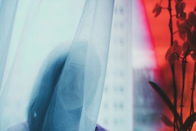 Close-up of woman looking through window