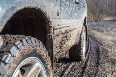 Close-up of car on dirt road