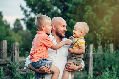 Father and sons against plants