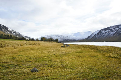 Scenic view of field and mountains against sky