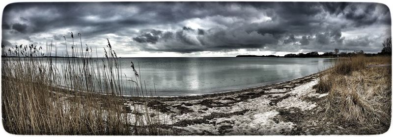 Scenic view of sea against cloudy sky