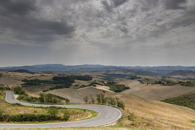 Scenic view of road by mountains against sky