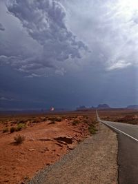 Road amidst land against sky