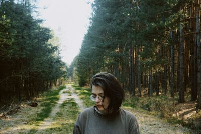 Rear view of woman standing in forest