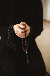 Prayer hands of a woman holding a rosary, ramadan kareem