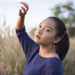 Portrait of cute girl with arms raised