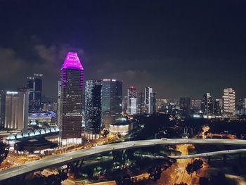 Illuminated buildings in city against sky at night