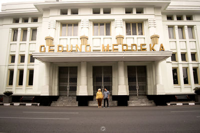 Rear view of people standing outside building