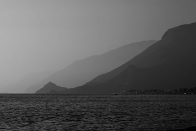 Scenic view of sea and mountains against clear sky