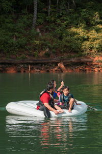 Man with children floating on lake