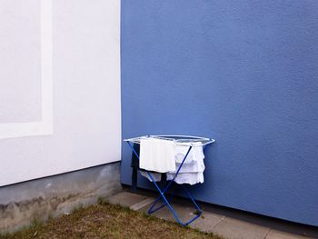 Chair against blue wall of building