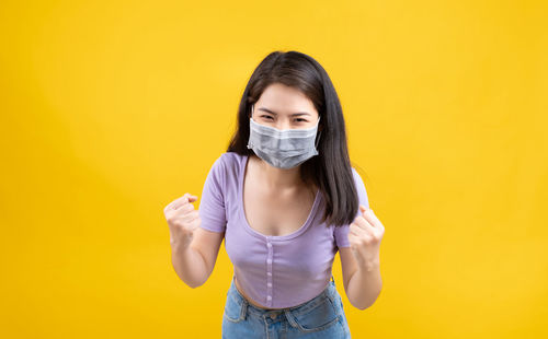 Portrait of a beautiful young woman over yellow background