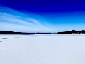 Scenic view of sea against blue sky during winter