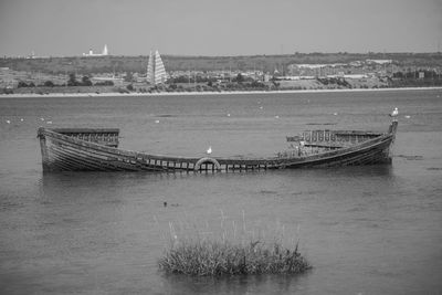 Boats in river with city in background