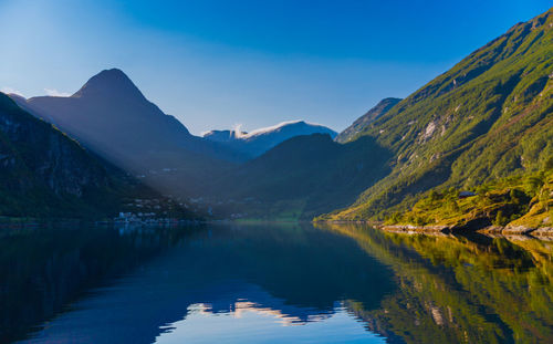Scenic view of lake by mountains against sky