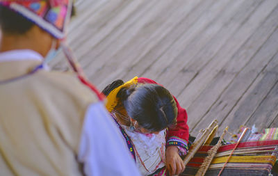 Indigenous woman showing traditional weaving technique and textile making in the andes mountain 