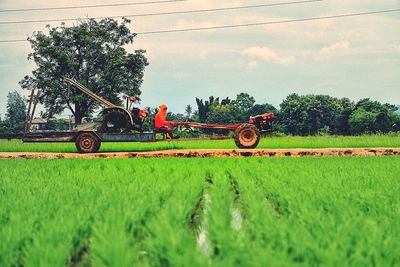 Tractor on agricultural field against sky