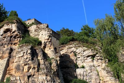 Low angle view of rocky landscape against blue sky