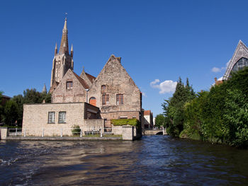 Historic building by trees against blue sky