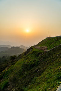 Scenic view of agricultural field against sky during sunset