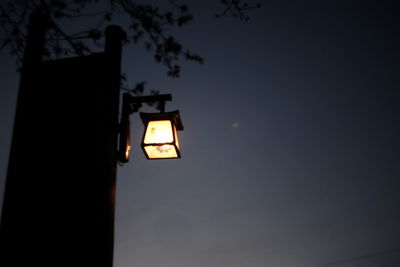 Low angle view of illuminated street light against sky