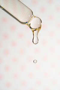 A dripping pipette with a drop of cosmetics gel.