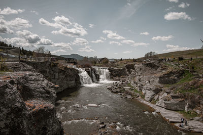 Scenic view of waterfall against sky