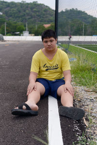 Portrait of boy sitting on road