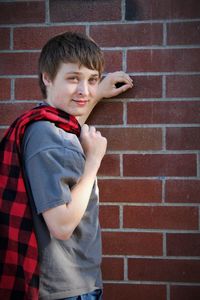 Portrait of boy standing against brick wall