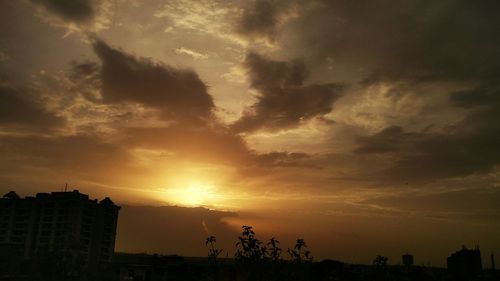 Silhouette of landscape against cloudy sky at sunset