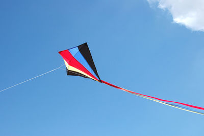 Low angle view of kite flying against blue sky