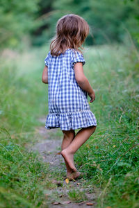 Rear view of girl standing on field