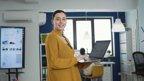 Portrait of young businesswoman using digital tablet in office