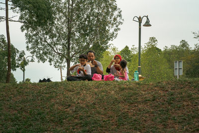 Rear view of woman sitting on grassy field