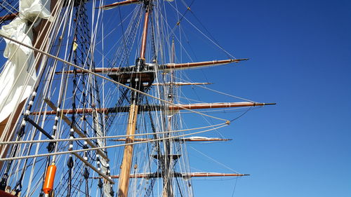 Low angle view of sailboat against clear blue sky