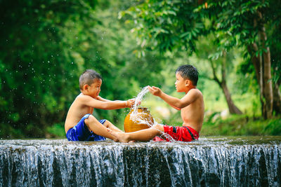 Side view of shirtless boy in water