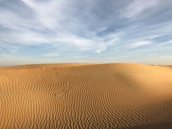 Sand dunes in desert against sky