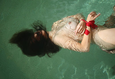 High angle view of woman relaxing in swimming pool