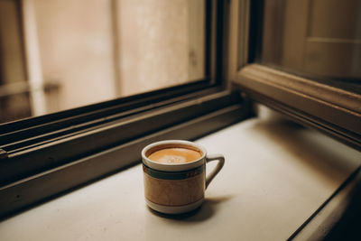 Coffee cup near the window with shutters in turin, italy. enjoy moment, relax lifestyle.