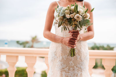 Midsection of woman holding flower bouquet