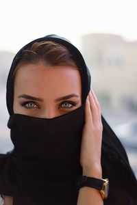 Portrait of woman covering face with headscarf