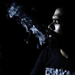 Close-up of man smoking in darkroom