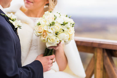 Midsection of woman holding flower bouquet