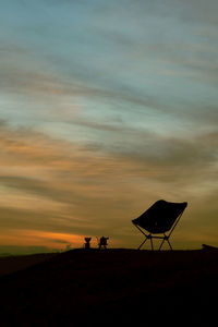 Silhouette man standing on beach against sky during sunset