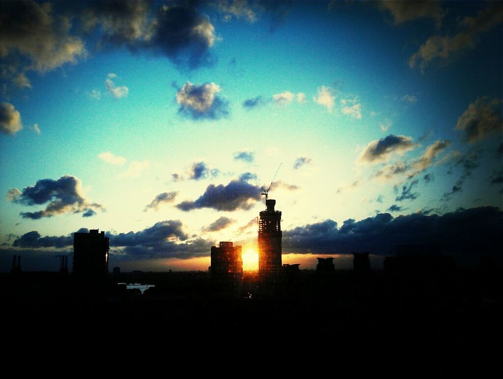 VIEW OF CITYSCAPE AGAINST CLOUDY SKY