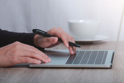 Midsection of man using laptop on table