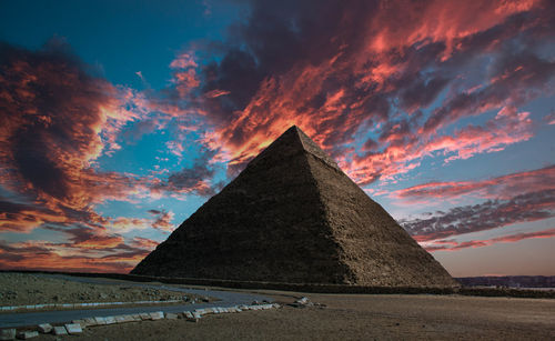 Smoke stacks against sky during sunset