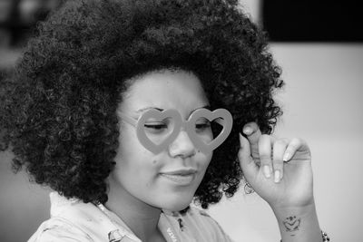 Close-up of woman with curly hair wearing novelty glasses at home